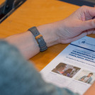 Flyer zur peer Beratung liegt auf einem Tisch und wird von den Händen einer Person umschlossen
