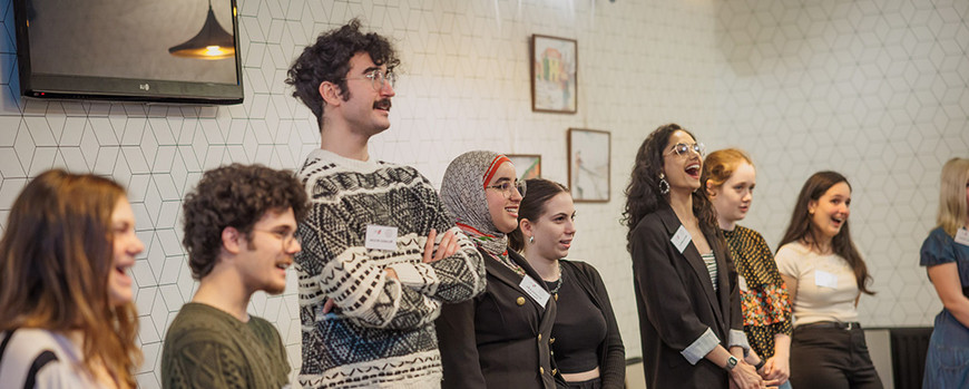 Internationale EDUC Studierende, die in einem Raum zusammen stehen und fröhlich lachen